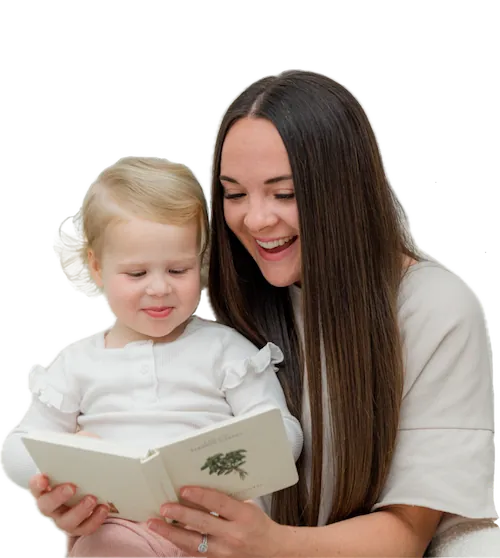 African American mother reading a bedtime story to her daughter seated in her lap